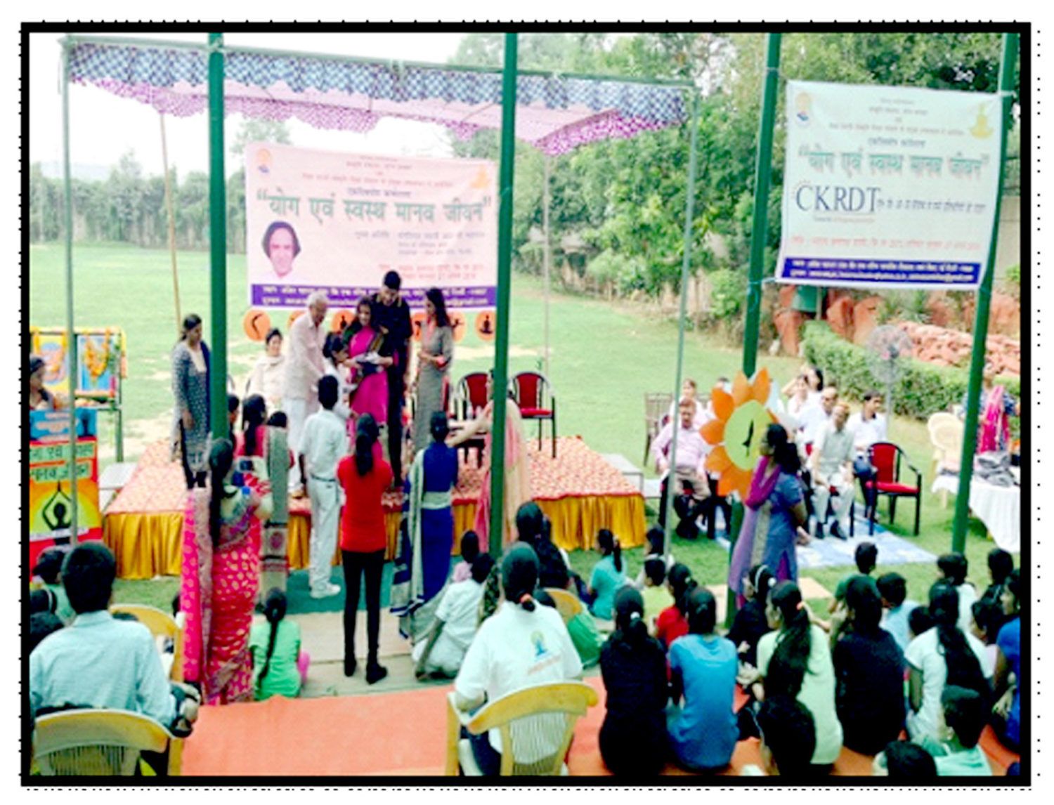 People in stage and in audience at event