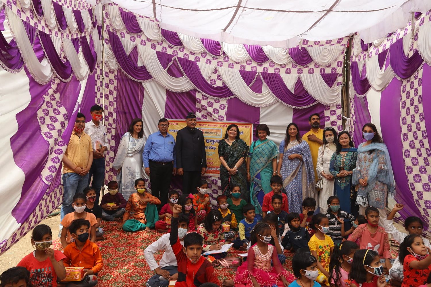 People standing and sitting in traditional ceremony to start construction of health centre