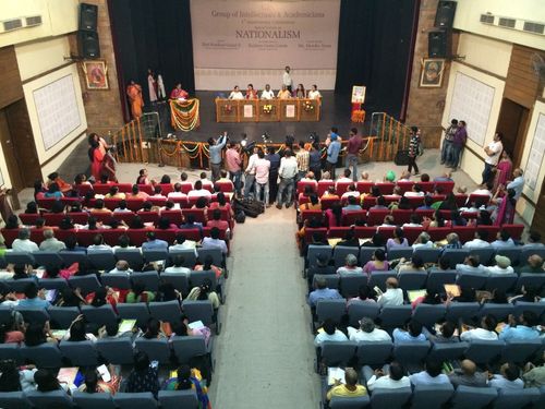 Auditorium with reporters asking questions from people on the stage