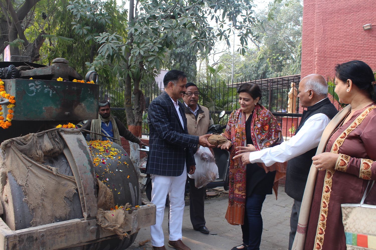 Mrs. Lalita Nijhawan and others participating in a ceremony to start road development work