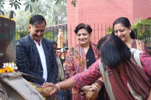 Mrs. Lalita Nijhawan and others participating in a ceremony to start road development work